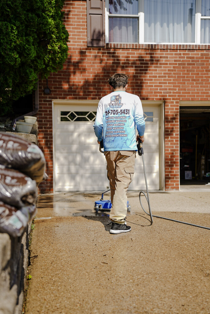 Pure Reflections pressure washing a concrete driveway in South Fayette, PA using a professional surface cleaner.