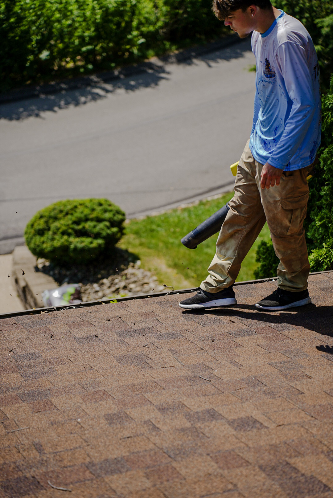 Pure Reflections technician performing gutter cleaning on a residential roof in Peters Township, PA.