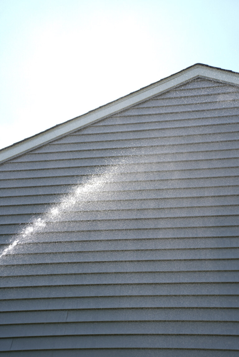 Soft washing vinyl siding on a residential home in Canonsburg, PA to remove algae and organic staining.