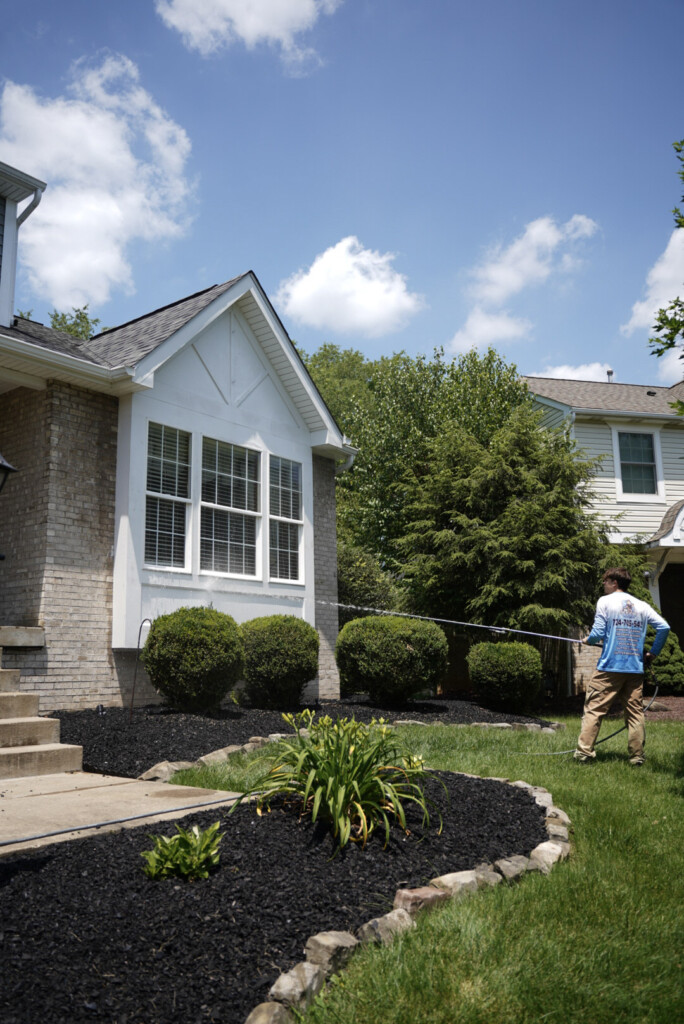 Exterior house washing service in Moon, PA cleaning white siding and brick safely with a soft wash system.
