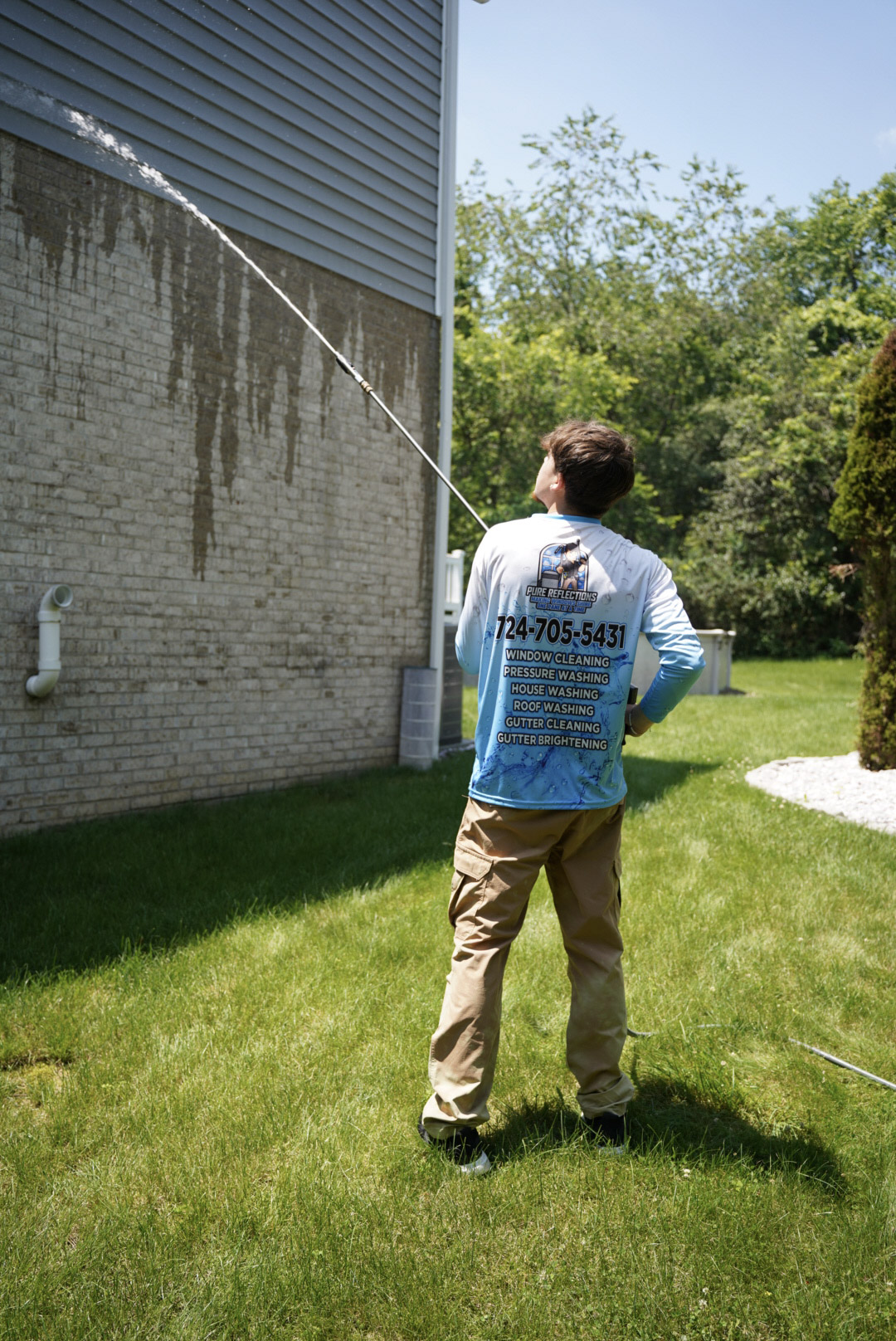 Professional house washing service removing algae and organic buildup from brick and vinyl siding in Venetia, PA.