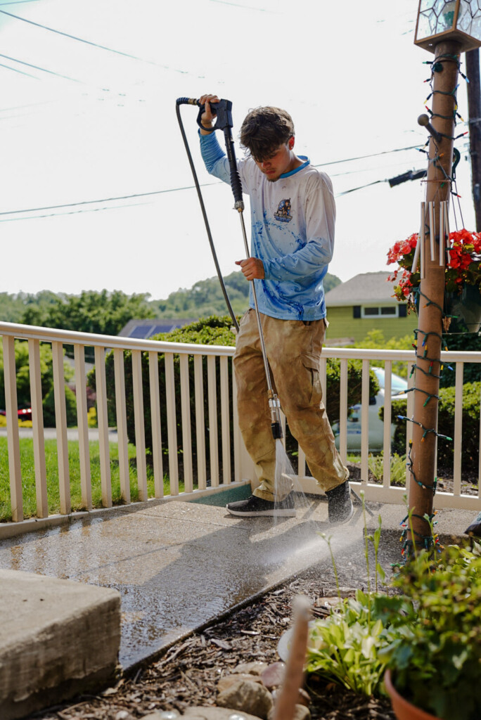Pure Reflections technician pressure washing a residential concrete porch in Jefferson Hills, PA.
