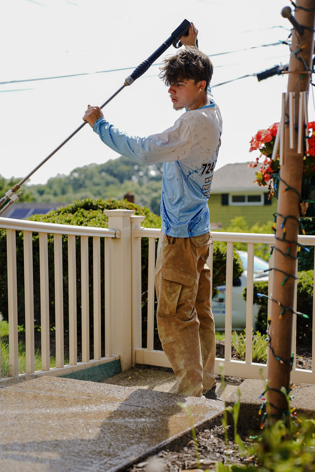 Pure Reflections technician pressure washing a concrete porch in West Mifflin, PA.