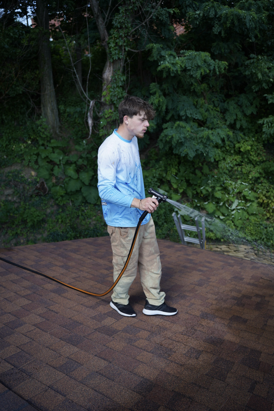 Roof cleaning service in Eighty Four, PA applying a soft wash solution to remove algae stains from asphalt shingles.