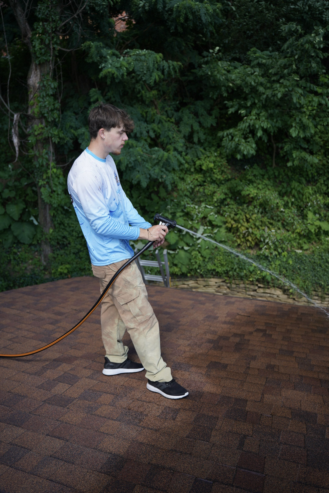 Roof cleaning service in Peters Township, PA removing black algae stains from asphalt shingles using a soft washing system.