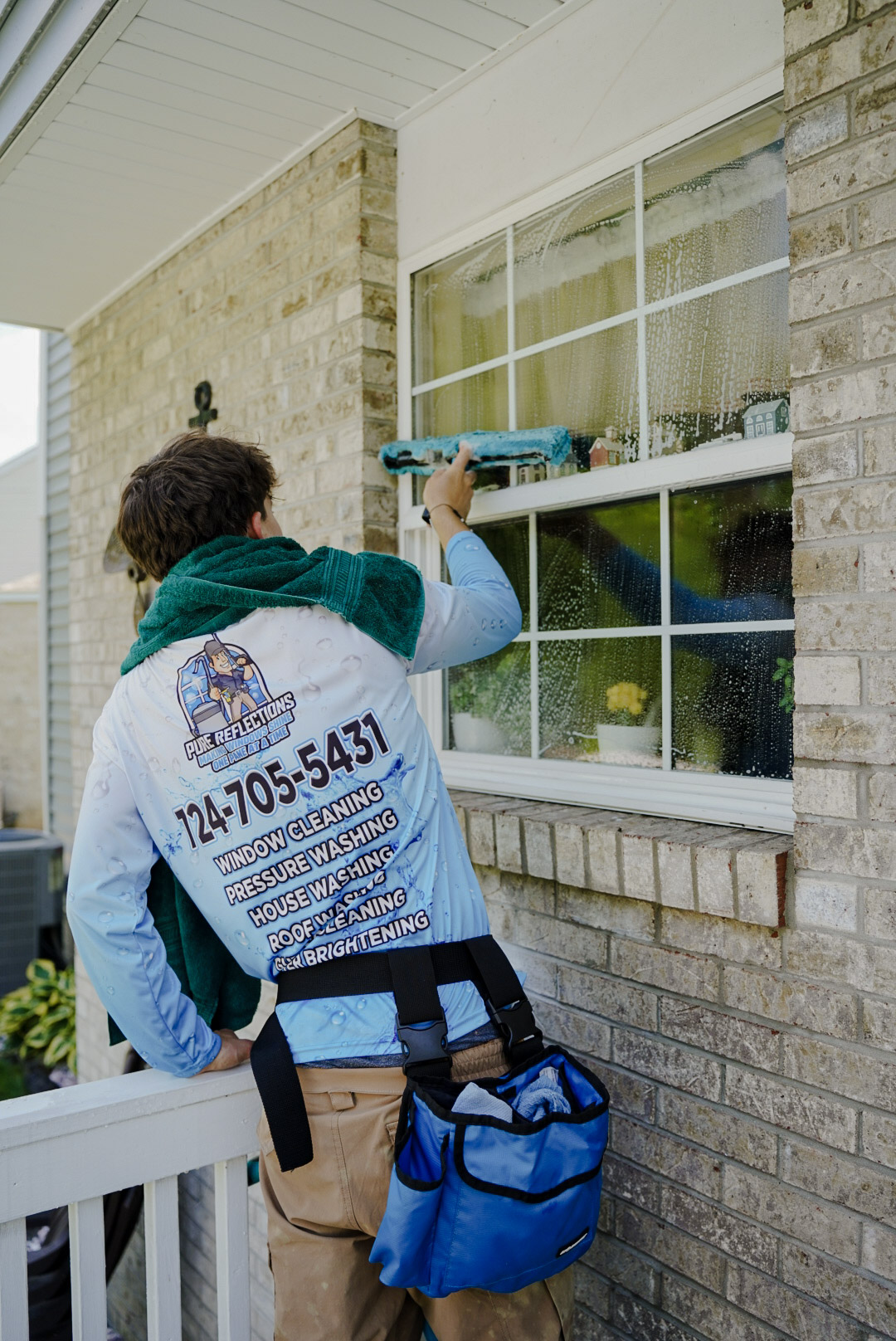 Pure Reflections technician providing residential window cleaning service in Bell Acres, PA cleaning exterior home windows.